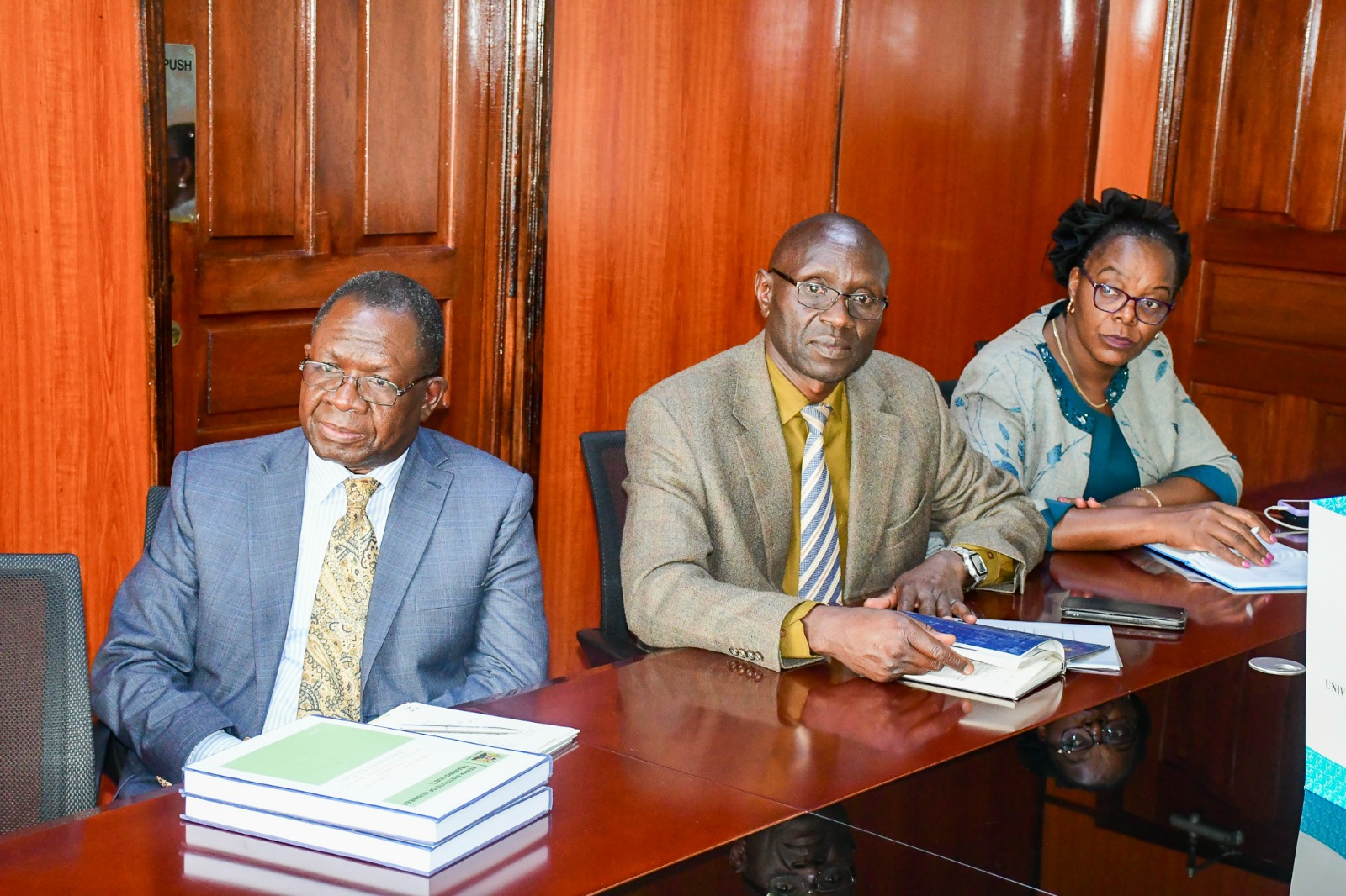 Ag. Director KIBT presents KIBT Training Manuals alongsides various staff at the ministry